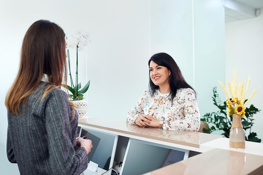 Woman smiling at front desk staff